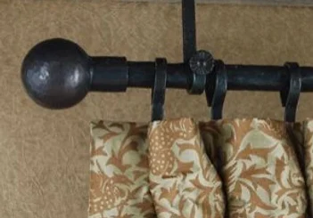 A close up of a curtain rod with two curtains hanging on it